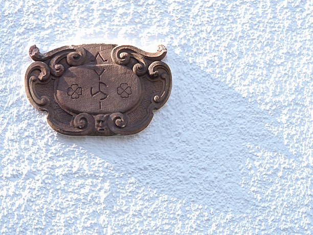 istock Old stone engraved plate on a white rendered medieval house 547538488