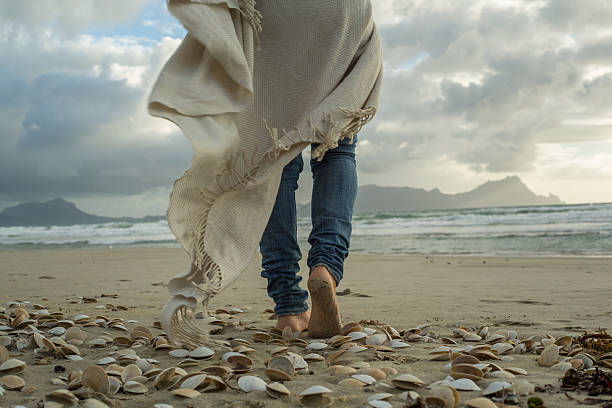 mujer caminando en la playa al atardecer - footprint sand sea beach fotografías e imágenes de stock