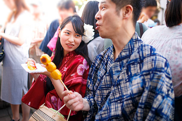 istock Japanese couple eating Dango rice dumpling at festival 547539724