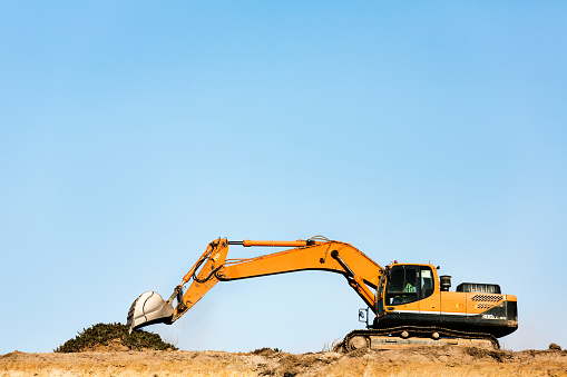 Track bulldozer, earth-moving equipment at a construction site on dull day. Land clearing, grading, ground excavation of large job of new residential building. Construction of heavy equipment for earthwork