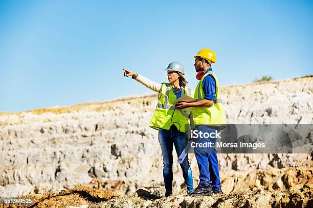 Architect Explaining Plan To Quarry Worker At Site Stock Photo - Download Image Now - Mining - Natural Resources, Miner, Construction Site