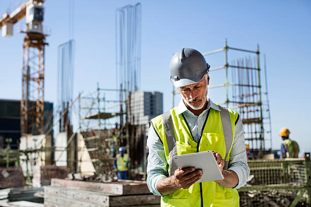 Architect using digital tablet at site Male architect using digital tablet at construction site against clear sky construction worker stock pictures, royalty-free photos & images