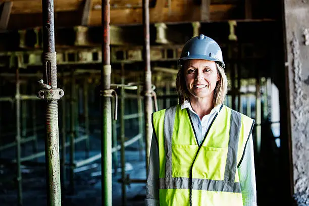 Portrait of happy female architect standing at construction site