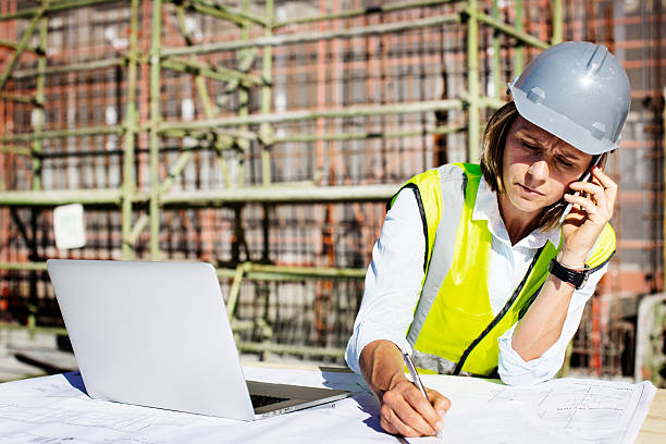 architect using mobile phone while working at site - computer construction using laptop construction site foto e immagini stock