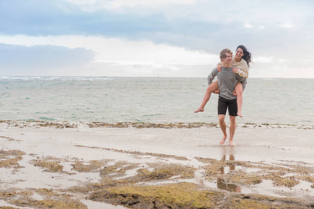 istock Young couple piggyback on tidal flats, beach 553141227