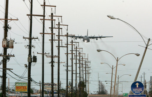 NEW ORLEANS - SEPTEMBER 13:  A U.S. Air Force C-130 plane flys just above power lines as it sprays pesticide September 13, 2005 in New Orleans, Louisiana. Pesticide was sprayed over areas with standing water that are expected to breed large numbers of mosquitos. Rescue efforts and clean up continue in the areas hit by Hurricane Katrina over two weeks after the deadly storm hit.  (Photo by Justin Sullivan/Getty Images)