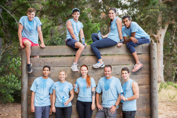 istock Portrait of confident team at wall on boot camp obstacle course 554392125