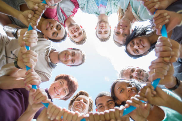 istock Portrait of team connected in circle around plastic hoop 554392173