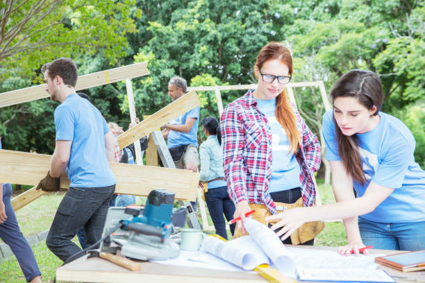 istock Volunteers reviewing blueprints at construction site 554392333