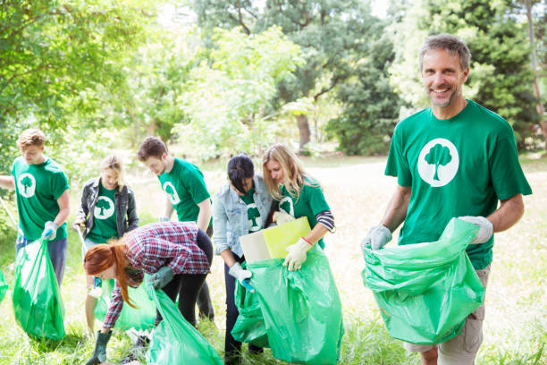 istock Portrait of smiling environmentalist volunteer picking up trash 554392459