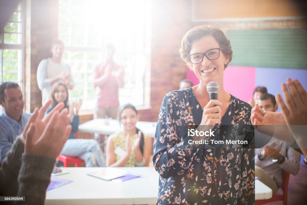 Audience clapping for woman in community center  18-19 Years Stock Photo