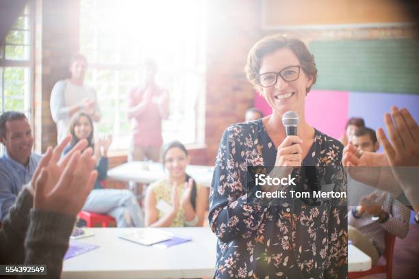 Audience Clapping For Woman In Community Center Stock Photo - Download Image Now - 18-19 Years, 20-24 Years, 25-29 Years