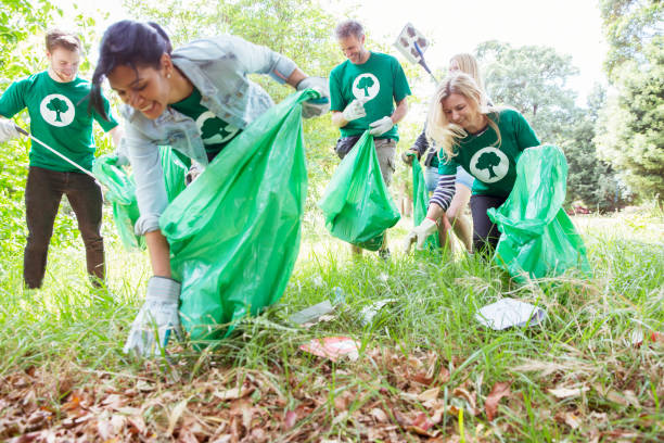 istock Environmentalist volunteers picking up trash in field 554392675
