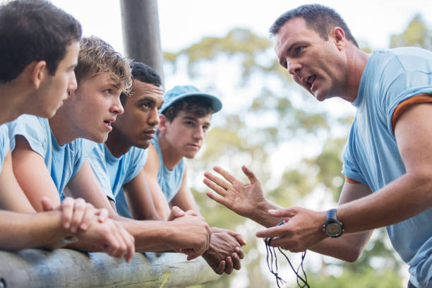 istock Team leader motivating team at boot camp obstacle course 554392719