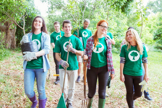 istock Smiling environmentalist volunteers planting new tree 554392747