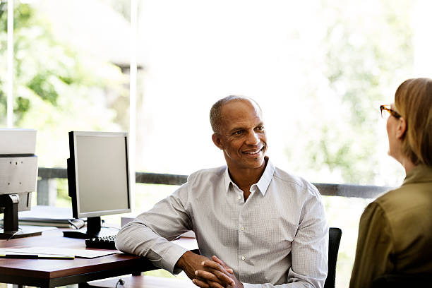 istock Businessman discussing with colleague in office 555250397