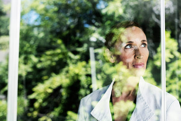 istock Thoughtful businesswoman by glass window 555250401
