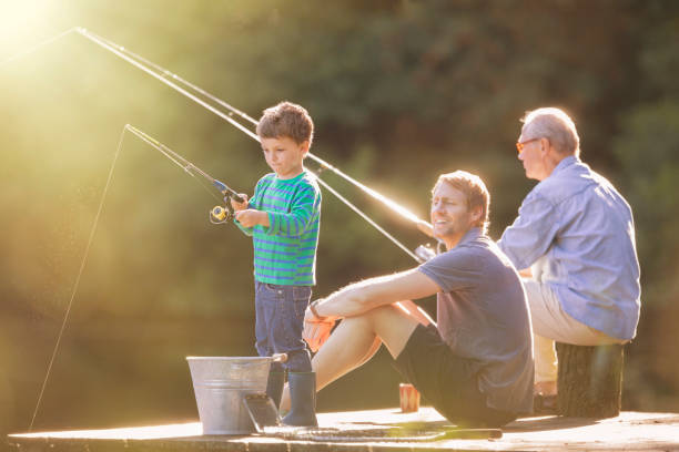 menino, pai e avô pescando em doca de madeira - fishing lake grandfather grandson - fotografias e filmes do acervo