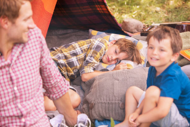 istock Father and sons smiling at camping tent 555799497