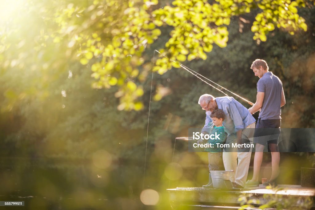 Boy, father and grandfather fishing in lake  Fishing Stock Photo