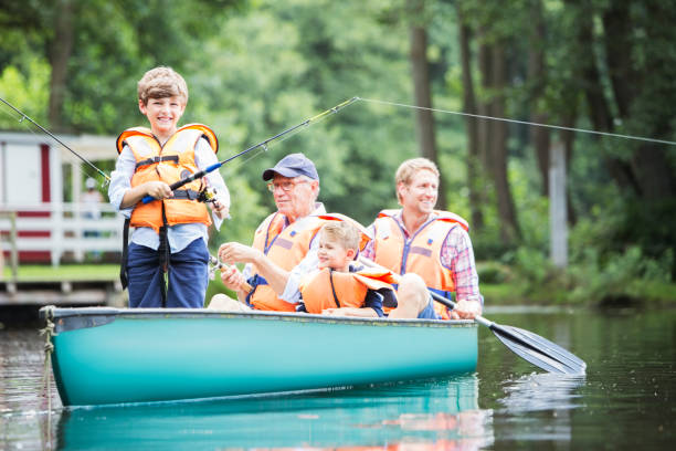 fratelli, padre e nonno che pescano nel lago - water sport lake canoe canoeing foto e immagini stock