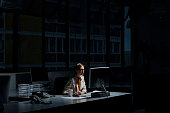 Businesswoman using computer in dark office