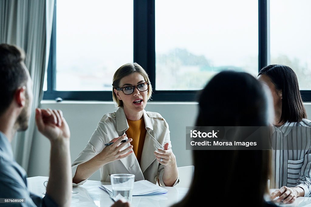 Businesswoman discussing plan with colleagues - 免版稅討論圖庫照片