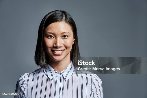 istock Smiling businesswoman over gray background 557608545