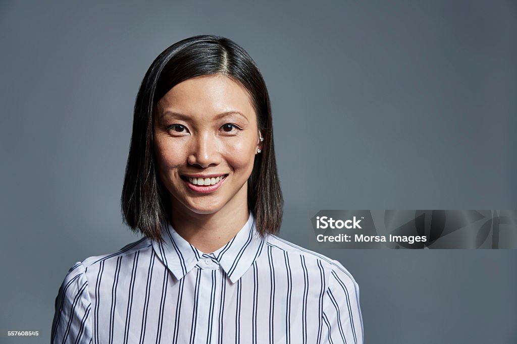 Smiling businesswoman over gray background - 免版稅畫像圖庫照片