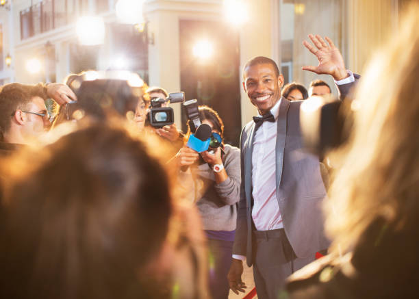 istock Celebrity waving for paparazzi with cameras at event 559536459
