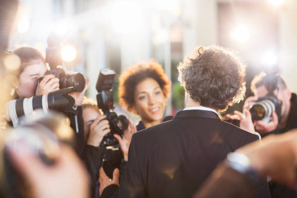 istock Celebrity being interviewed and photographed by paparazzi at event 559536571