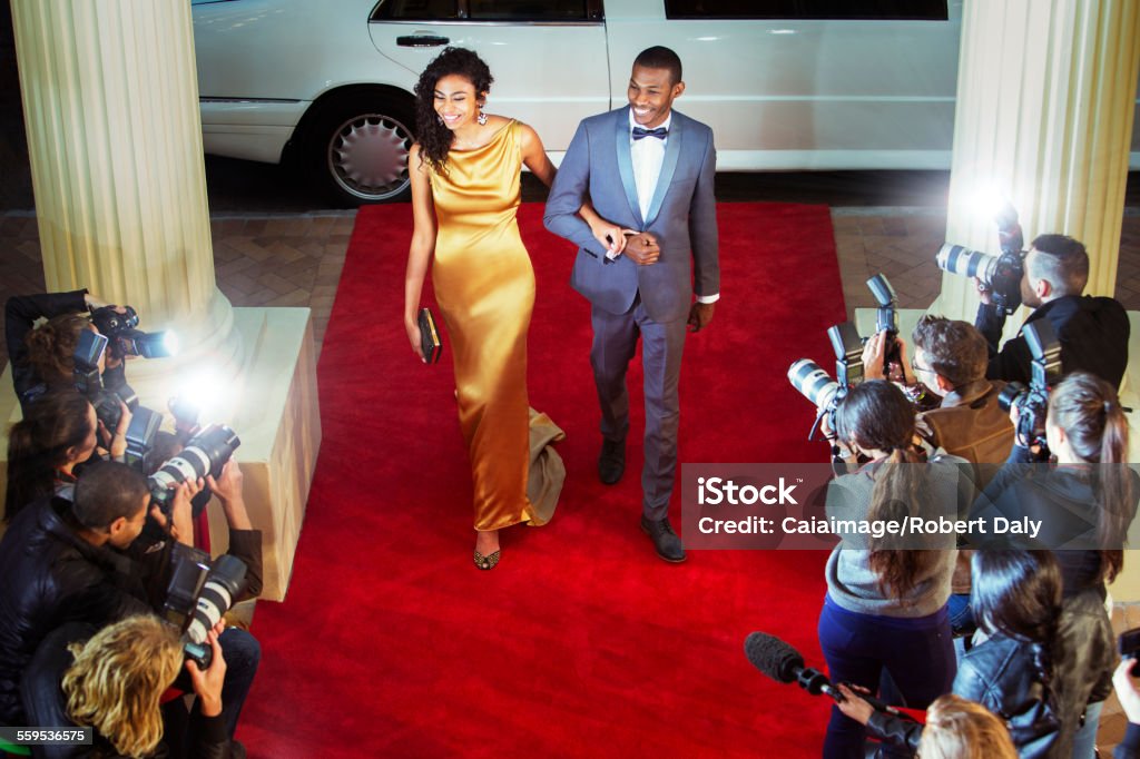 Celebrity couple arriving at red carpet event and being photographed by paparazzi  Red Carpet Event Stock Photo