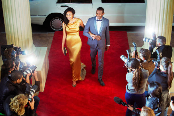 para celebrytów przybywająca na imprezę na czerwonym dywanie i fotografowana przez paparazzi - evening gown flash zdjęcia i obrazy z banku zdjęć
