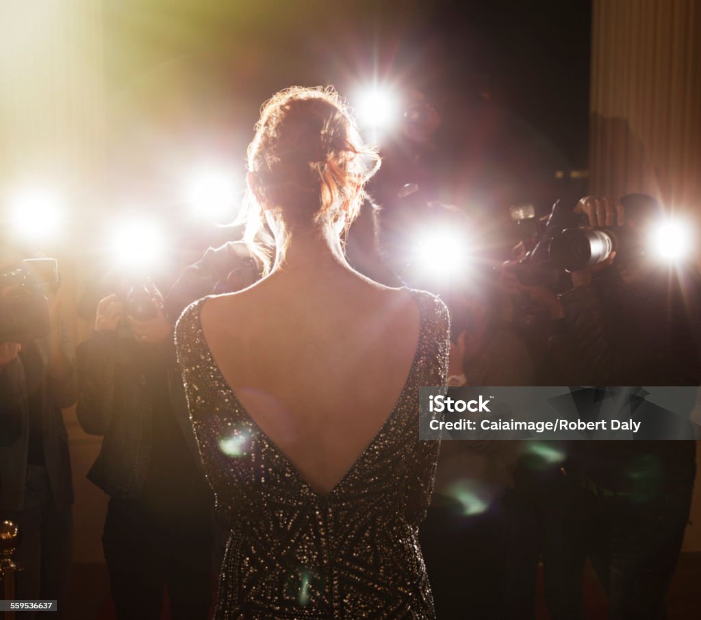 Celebrity facing paparazzi photographers at event  Red Carpet Event Stock Photo