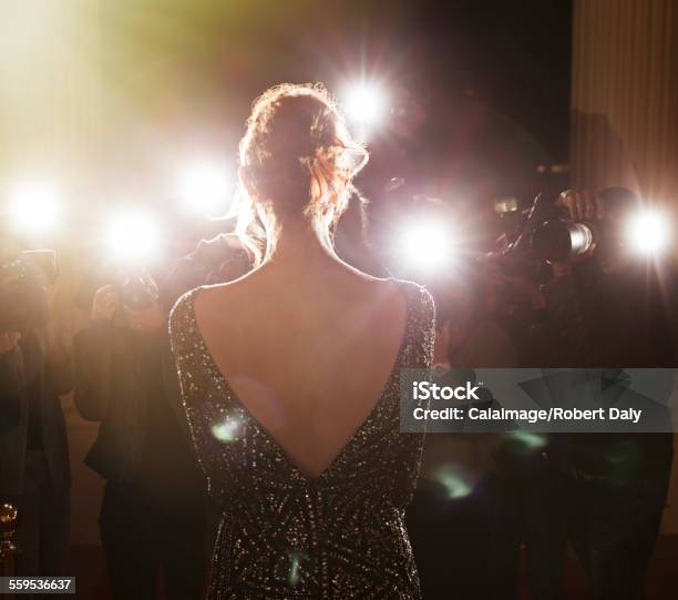 Celebrity Facing Paparazzi Photographers At Event Stock Photo - Download Image Now - Red Carpet Event, Women, Camera Flash