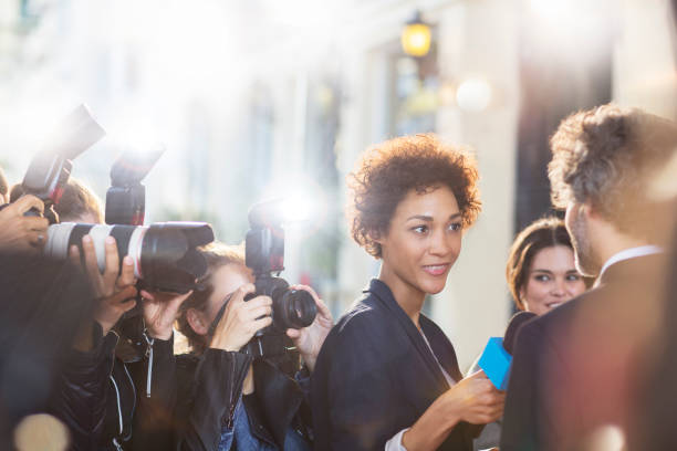 istock Celebrity being interviewed and photographed by paparazzi at event 559536639