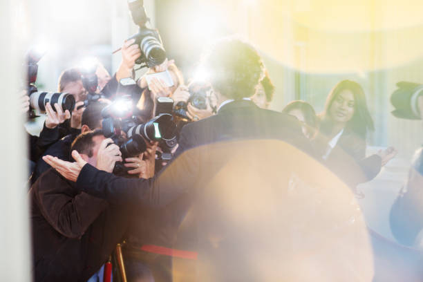 istock Celebrity being photographed by paparazzi at event 559536657