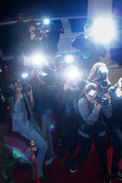 istock Paparazzi photographers pointing cameras at red carpet event 559536713