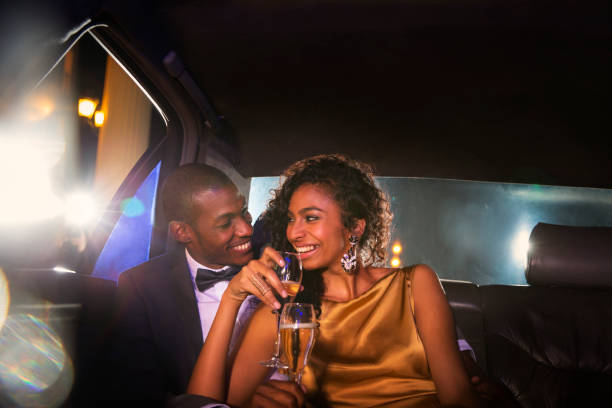 coppia di celebrità che beve champagne all'interno di limousine all'esterno dell'evento - limousine foto e immagini stock