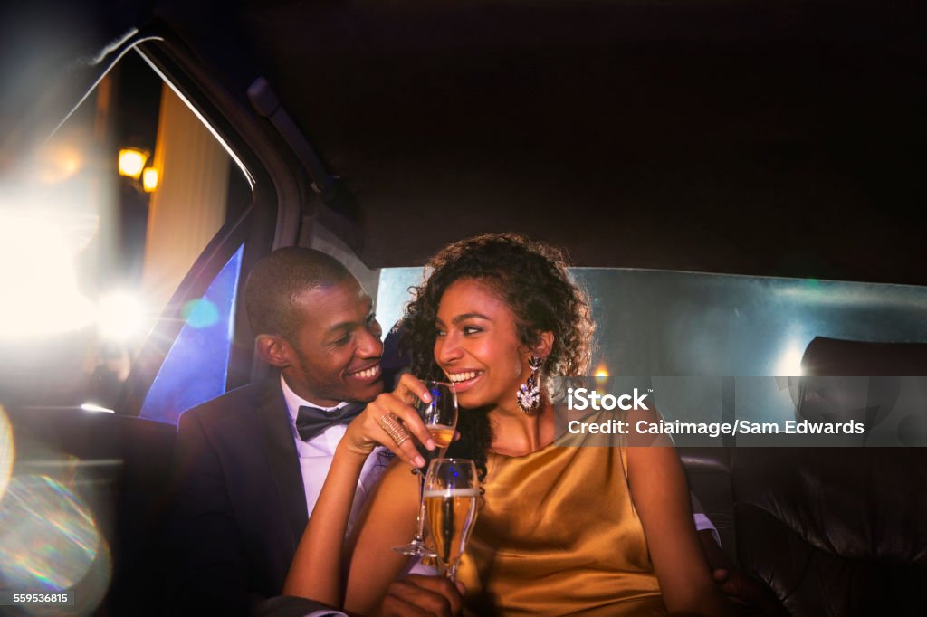 Celebrity couple drinking champagne inside limousine outside event  Limousine Stock Photo