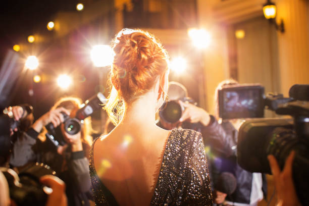 Celebrity being photographed by paparazzi photographers at event stock photo