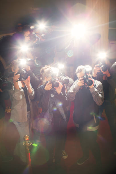 istock Lens flare flash from paparazzi photographers cameras 559536895