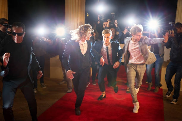 Enthusiastic celebrities arriving and running from paparazzi at red carpet event  boy band stock pictures, royalty-free photos & images