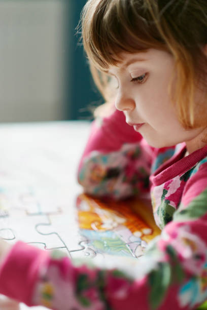 istock Close up of serious girl assembling jigsaw puzzle 559537539