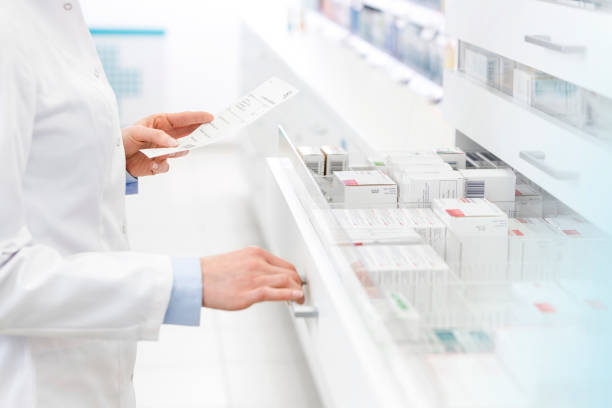 Pharmacist filling prescription in pharmacy stock photo