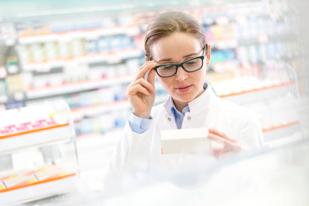 istock Pharmacist reading label on box in pharmacy 559537935