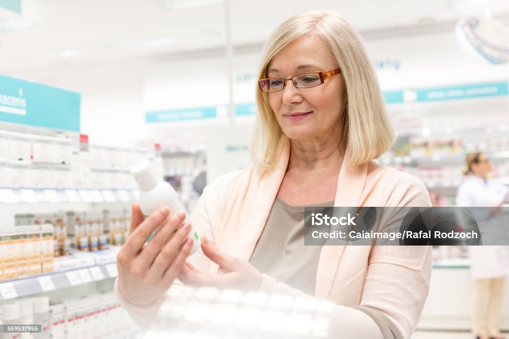 Customer reading label on bottle in pharmacy  Moisturizer Stock Photo
