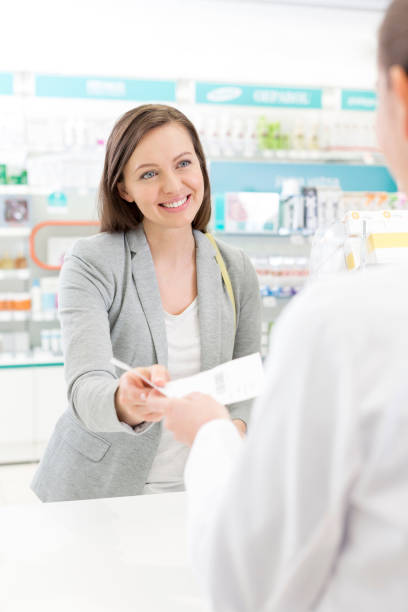 istock Smiling customer giving prescription to pharmacist in pharmacy 559538007