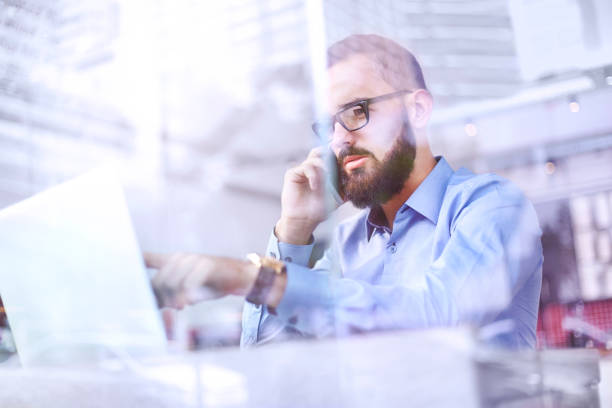 istock Businessman talking on cell phone and using laptop 559538215