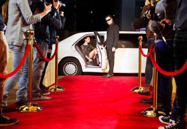 guardaespaldas que abre limusina para celebridades que llegan al evento de alfombra roja - estreno de película fotografías e imágenes de stock